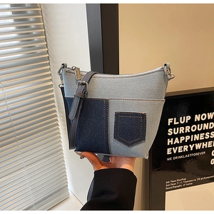 Detailansicht der Patchwork-Denim-Umhängetasche mit Ziertaschen und feinen Riemen