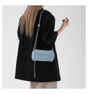 Détail du sac cylindrique en tweed bleu clair avec paillettes et bandoulière dorée