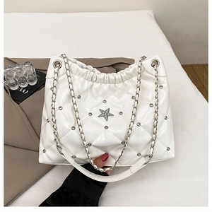 Détail du sac fourre-tout matelassé blanc avec clous argentés et emblème étoile