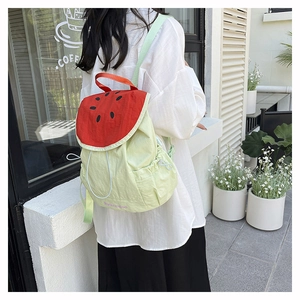 Outdoor shot of a girl wearing a creative watermelon-shaped canvas backpack with straps