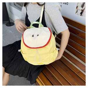 Detailed view of apple-shaped backpack featuring creative fruit design and yellow nylon