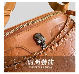 Detail of brown leather saddle bag with skull embossing and rhinestone metal buckle
