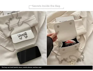 Detail view of cream leather crossbody bag with silver bow buckle and interior capacity