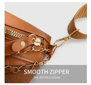 Macro detail of brown leather bag showing embossed bear pattern and golden zipper hardware