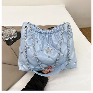 Détail du sac cabas matelassé bleu clair avec étoile en strass et chaîne argentée