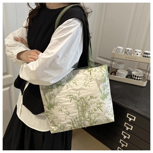 Detail of large nylon tote bag featuring green bamboo prints and reinforced green straps