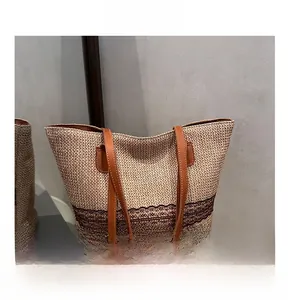 Detail of woven straw tote bag with brown leather straps and delicate lace trim