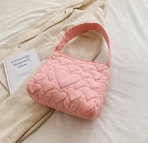 Detail showing heart-shaped quilted pattern on pink fashion shoulder tote bag
