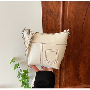 Nahaufnahme der cremefarbenen PU-Ledertasche mit Ziernähten und silbernen Beschlägen