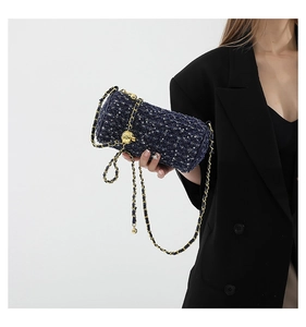 Détail du sac cylindre en tweed bleu marine à paillettes avec chaîne et fermoir lion doré