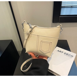Detailansicht der cremeweißen Ledertasche mit Kontrastnähten und silbernen Beschlägen