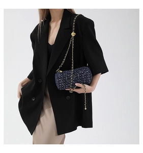 Détail du sac cylindre en tweed avec chaîne dorée et boucle à bille ajustable