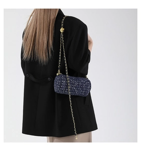 Vue détaillée d'un sac cylindre en tweed bleu avec chaîne dorée et breloque fleurie