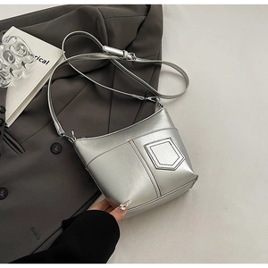 Detail der silbernen Metallic-Schultertasche mit asymmetrischer Naht und Riemen