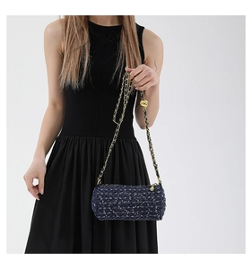 Détail du sac cylindre en tweed bleu avec chaîne dorée réglable et paillettes brillantes