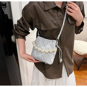 Détail du sac bandoulière argenté matelassé avec chaîne en perles et bandoulière réglable