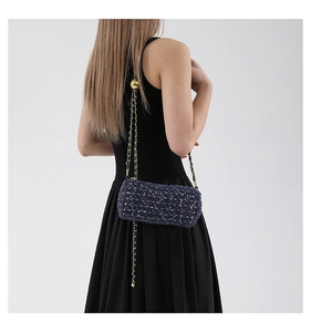 Détail du sac cylindre en tweed bleu avec fils argentés et bandoulière chaîne dorée