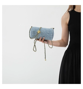 Vue macro du sac cylindre en tweed bleu clair avec paillettes argentées et chaîne dorée