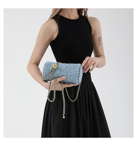 Détail du sac cylindre en tweed bleu avec matelassage en losanges et chaîne dorée