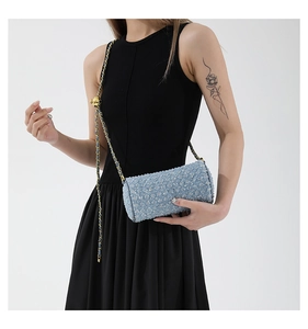 Détail du sac cylindre en tweed bleu clair avec motif matelassé et chaîne dorée