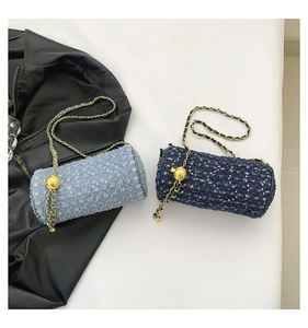 Détail du sac cylindrique matelassé en jean avec chaîne à bille dorée ajustable