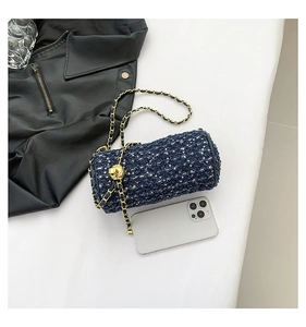 Détail du sac cylindre en tweed bleu avec chaîne dorée et fermoir sphérique