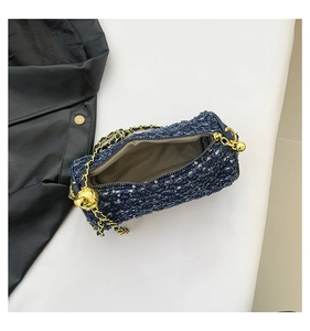 Détail du sac cylindre en tweed bleu montrant la doublure et la bandoulière dorée