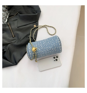 Détail du sac cylindre en jean bleu clair avec paillettes argentées et chaîne dorée