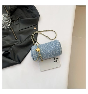 Détail du sac cylindre en tweed bleu clair avec paillettes argentées et chaîne à nœud doré