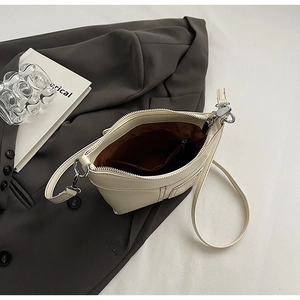 Draufsicht der cremefarbenen Ledertasche mit braunem Innenfutter und Reißverschlussfach