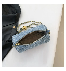 Détail du sac cylindrique en tweed bleu clair avec paillettes argentées et chaîne dorée