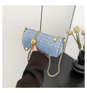 Gros plan sur le sac cylindrique en jean bleu clair avec paillettes et chaîne dorée