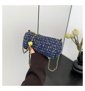 Détail d'un sac cylindre en tweed bleu avec paillettes argentées et chaîne dorée