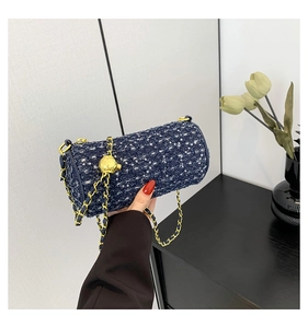 Détail du sac cylindre en jean bleu avec texture tweed à paillettes et chaîne