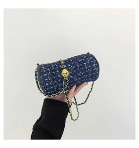 Détail du sac cylindre en tweed bleu marine avec paillettes et bandoulière dorée