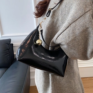 Glanzende zwarte lakleren halve maan tas met gouden bolletje en reliëf fashion details
