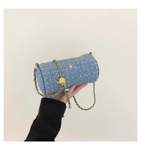 Détail du sac cylindre en denim matelassé avec sequins argentés et chaîne dorée à boule