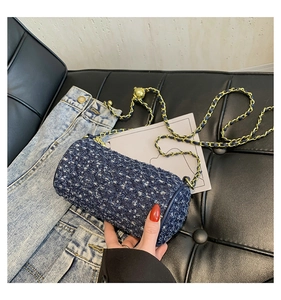 Détail du sac cylindre en jean bleu foncé avec paillettes et chaîne dorée chic