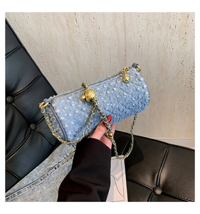 Détail du sac cylindre en jean bleu clair avec paillettes argentées et breloque dorée