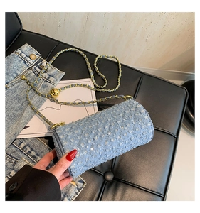 Détail du sac cylindre en jean bleu avec paillettes et bandoulière chaîne dorée
