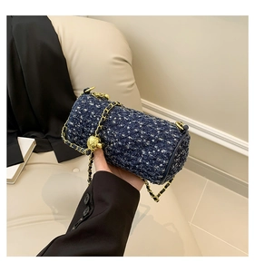 Détail du sac cylindrique en tweed à paillettes bleues avec chaîne dorée réglable à la main