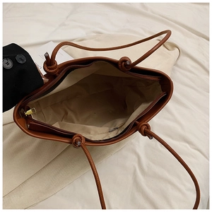 Detailed view of brown woven tote bag interior with zipper pocket and light fabric lining