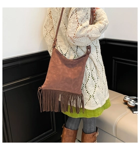 Close-up of brown suede crossbody bag with long tassels and retro bohemian texture