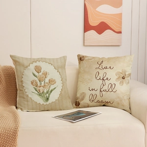 Set mit 2 Vintage-Leinenkissen mit Tulpenmotiven auf einem gemütlichen beigen Sofa