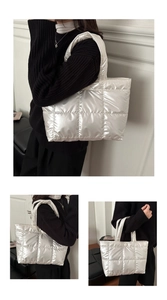Detailed close-up showing the glossy silver quilted puffer fabric and large capacity of the tote bag