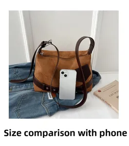 Detail of brown suede crossbody bag compared with a smartphone for size reference
