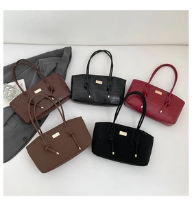 Detail view of stylish tote bags in crocodile pattern and smooth leather with gold buckles