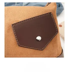 Detail of yellow suede shoulder bag with brown leather pocket and silver metal rivet
