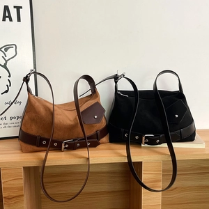 Detail of caramel brown and black suede shoulder bags with retro leather belt buckle designs