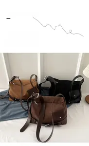 Close-up of suede shoulder bags with leather straps and silver buckle adjustment detail